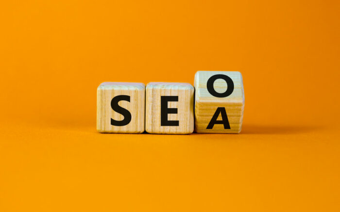 SEO vs SEA. Turned a cube and changed the word 'SEA - search engine advertising' to 'SEO - search engine optimization'. Business and SEO or SEA concept. Beautiful orange background, copy space.