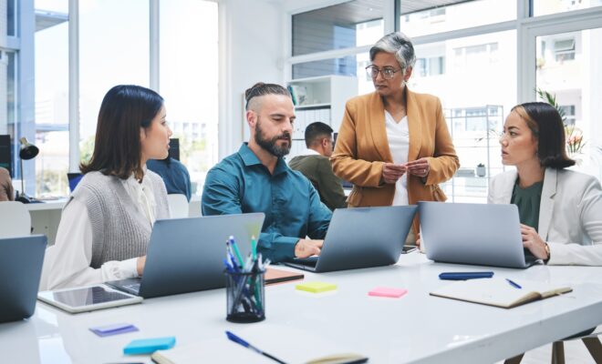 Business people, laptop and meeting, marketing team at digital agency, creative group and research