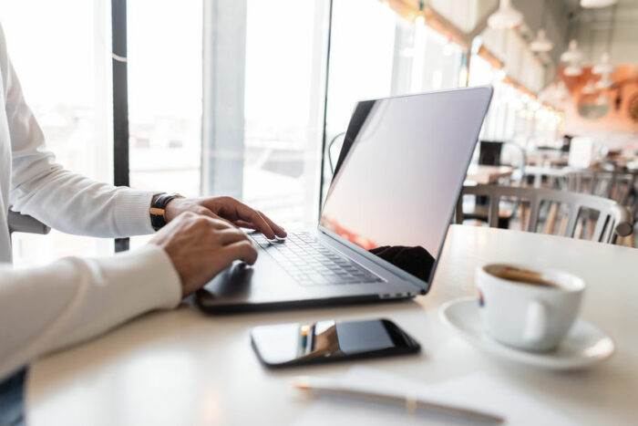 Successful businessman working behind a laptop in a cafe. Blogge