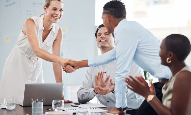 Handshake, team and agreement on business partnership meeting, merger or success on b2b collaborati