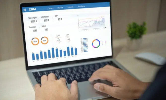 Man using computer laptop software with graphs and charts showing sales data. CRM Customer