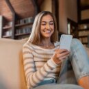 Portrait of smiling woman using smartphone at home