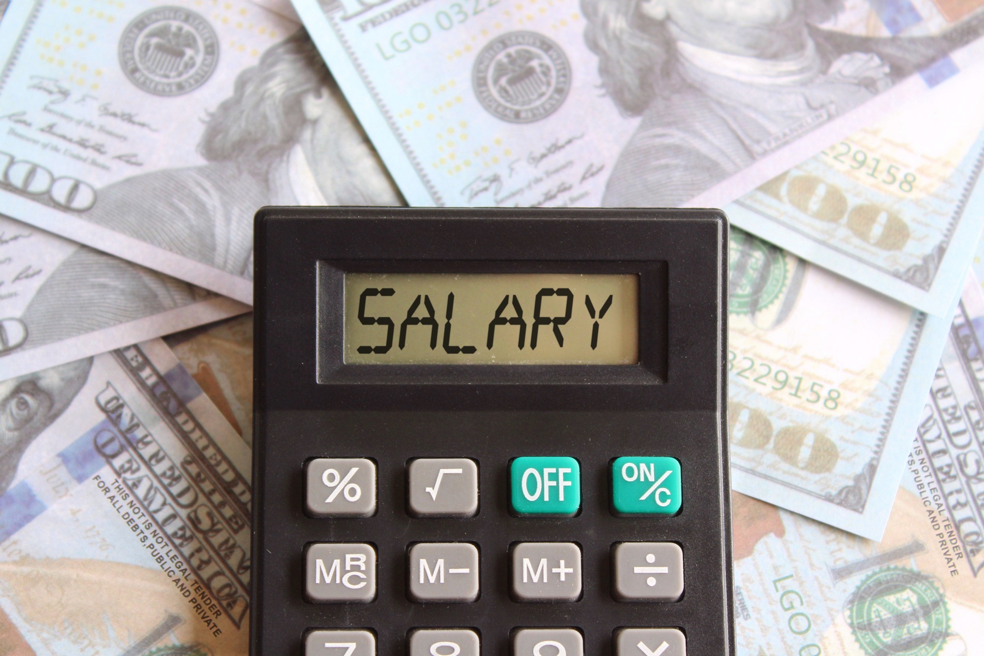 Top view image of calculator with text SALARY and money